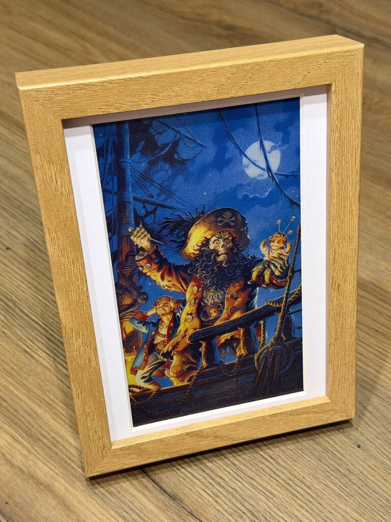 The poster art of the Monkey Island 2 videogame, showing the pirate LeChuck using a voodoo doll of Guybrush, the protagonist of the game, displayed on an e-paper art frame. The many weirdly colored pixels in the previous image no longer look weird, as it turns out their real life equivalents are not as bright.